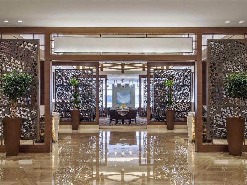 Jabal Omar Hyatt Regency Makkah Hotel Mecca Exterior photo The photo showcases a modern, elegant interior space, likely within a hotel or upscale establishment. It features decorative screens made of intricate patterns that serve as partitions. The floor is polished marble, reflecting the bright lighting abo