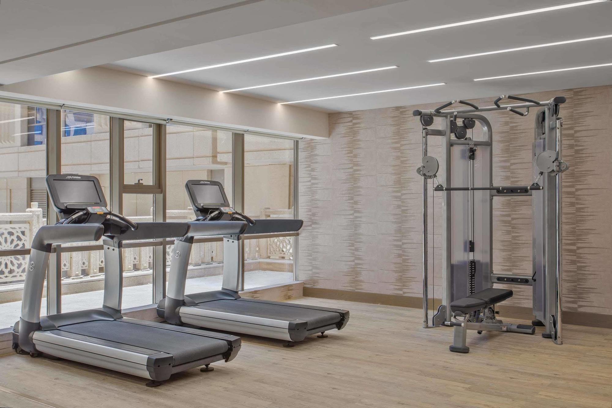 Jabal Omar Hyatt Regency Makkah Hotel Mecca Exterior photo The photo shows a modern gym area featuring two treadmills positioned side by side. Next to them is a multi-functional gym machine designed for strength training, which includes various attachments for different exercises. The gym has a bright, airy 