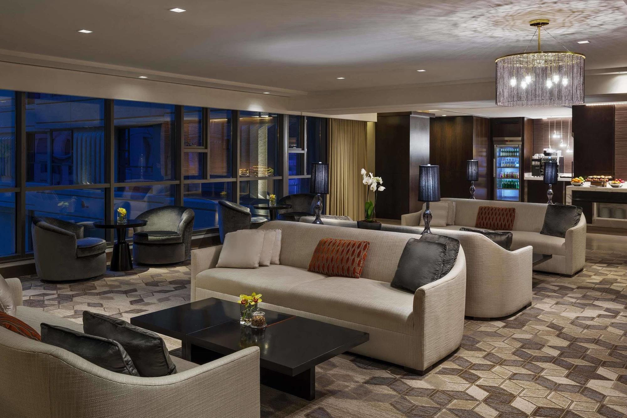 Jabal Omar Hyatt Regency Makkah Hotel Mecca Exterior photo The photo shows a modern and elegant lounge area. It features comfortable cream-colored sofas arranged in a cozy setting, along with dark coffee tables. The space is illuminated by warm lighting, including a stylish chandelier. Large windows allow fo