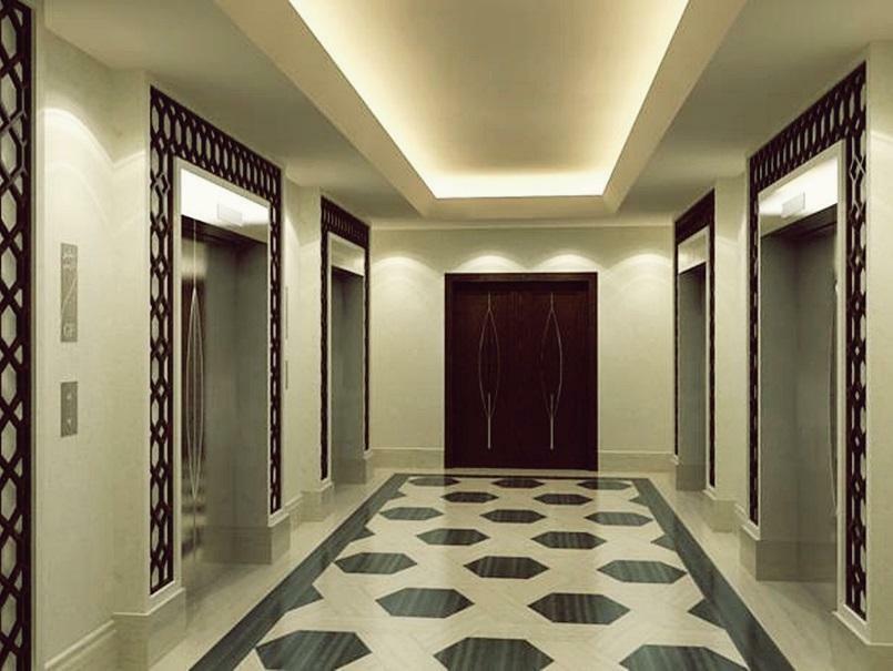 Jabal Omar Hyatt Regency Makkah Hotel Mecca Exterior photo The photo shows a modern, elegantly designed hotel hallway. It features a symmetrical layout with two sets of elevators on either side. The walls are a soft cream color, which enhances the overall brightness of the space. A sophisticated pattern can 